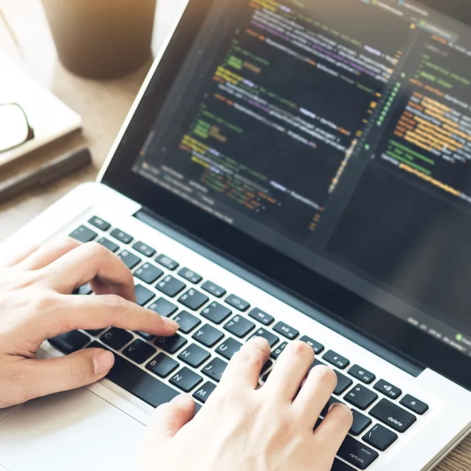 Handen typen code op een laptop